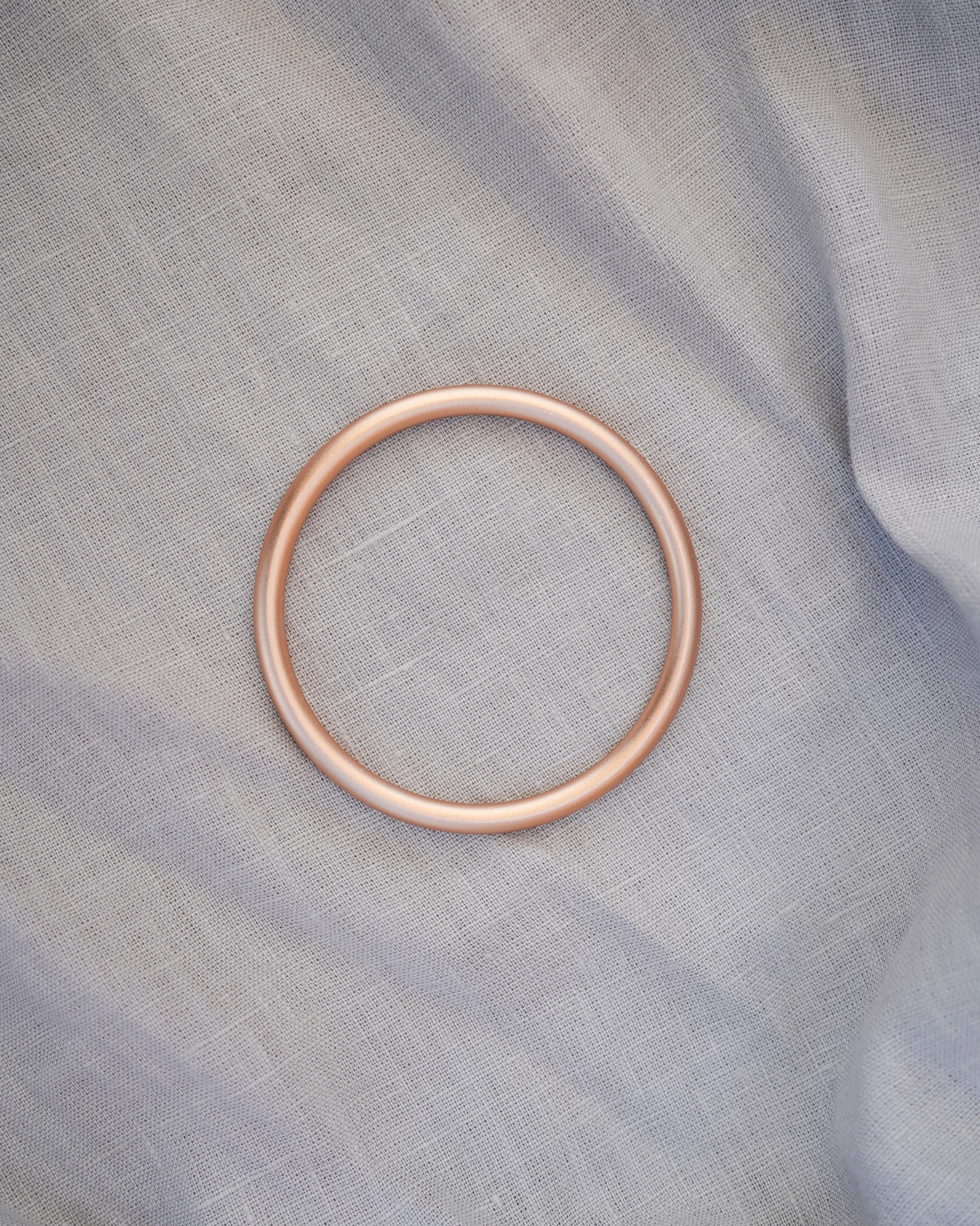 Goldener Ring auf hellgrauer Ringsling
