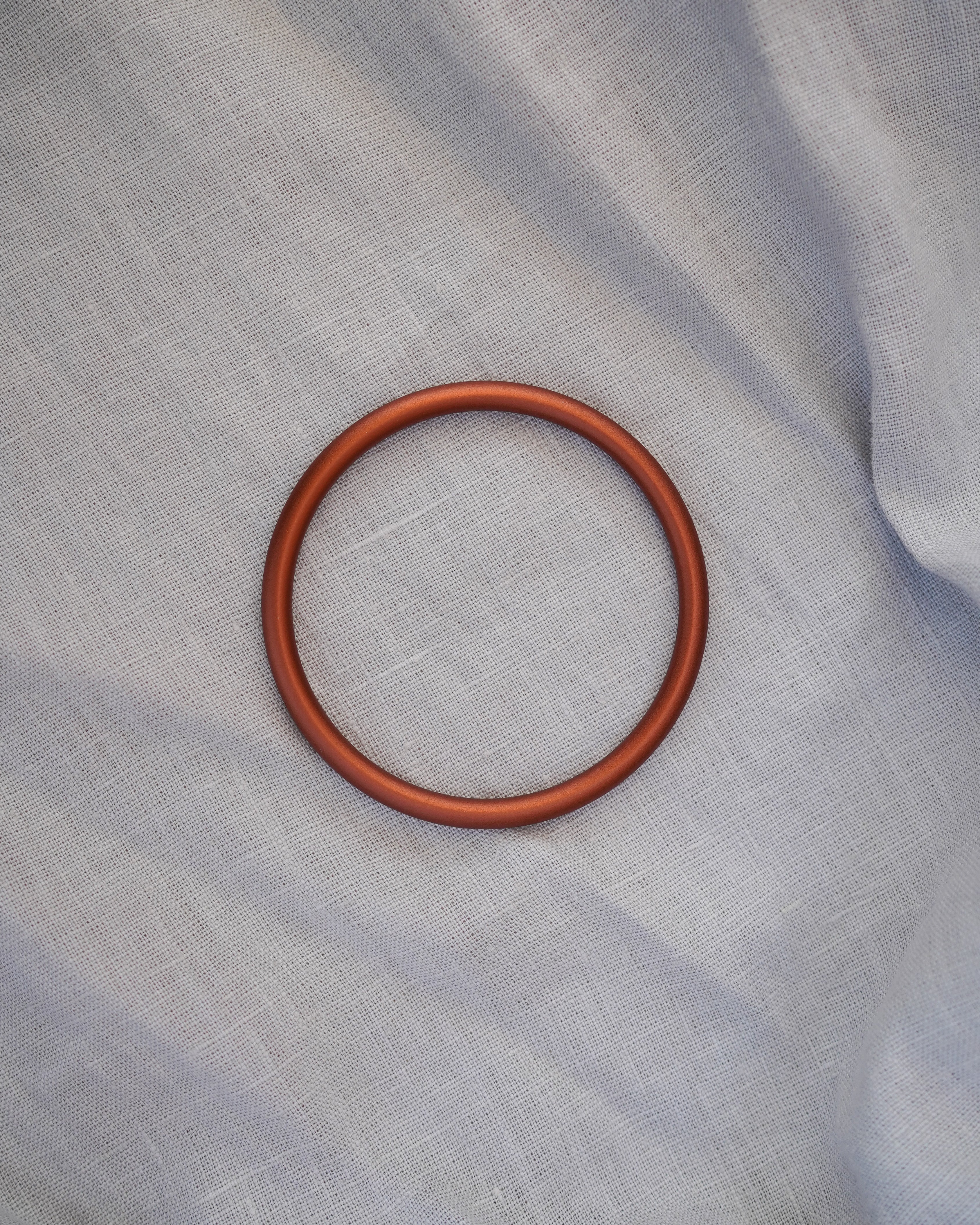 Bronze Ring auf hellgrauer Ring Sling